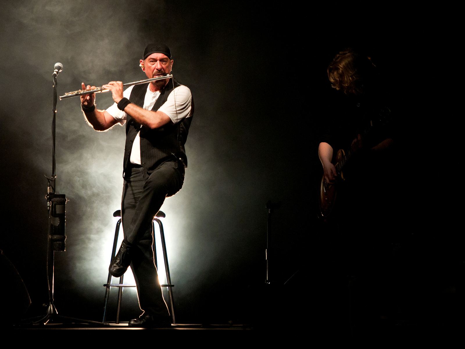 Ian Anderson dei Jethro Tull suona il flauto traverso in equilibrio su una gamba sola durante un concerto